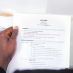 Close-up Of A Looking At a Internship Resume Holding In Hand