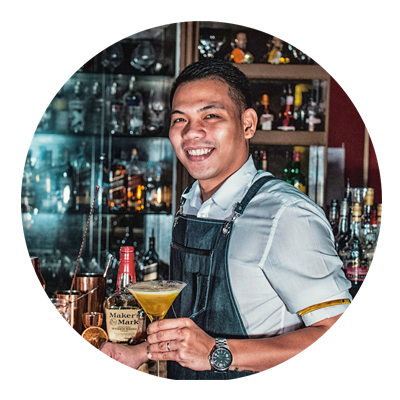 smiling bartender with cocktail in his hand