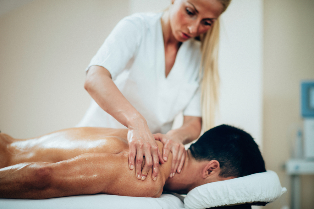Message therapist giving shoulder massage